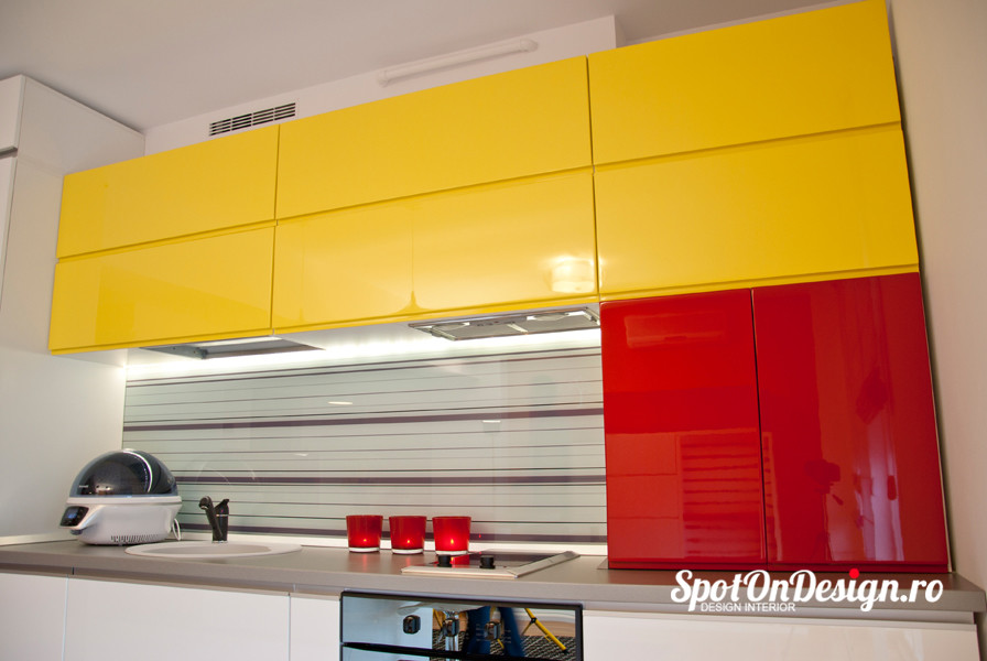 This is an example of a small modern single-wall eat-in kitchen in Other with a single-bowl sink, flat-panel cabinets, yellow cabinets, laminate benchtops, multi-coloured splashback, glass sheet splashback and ceramic floors.