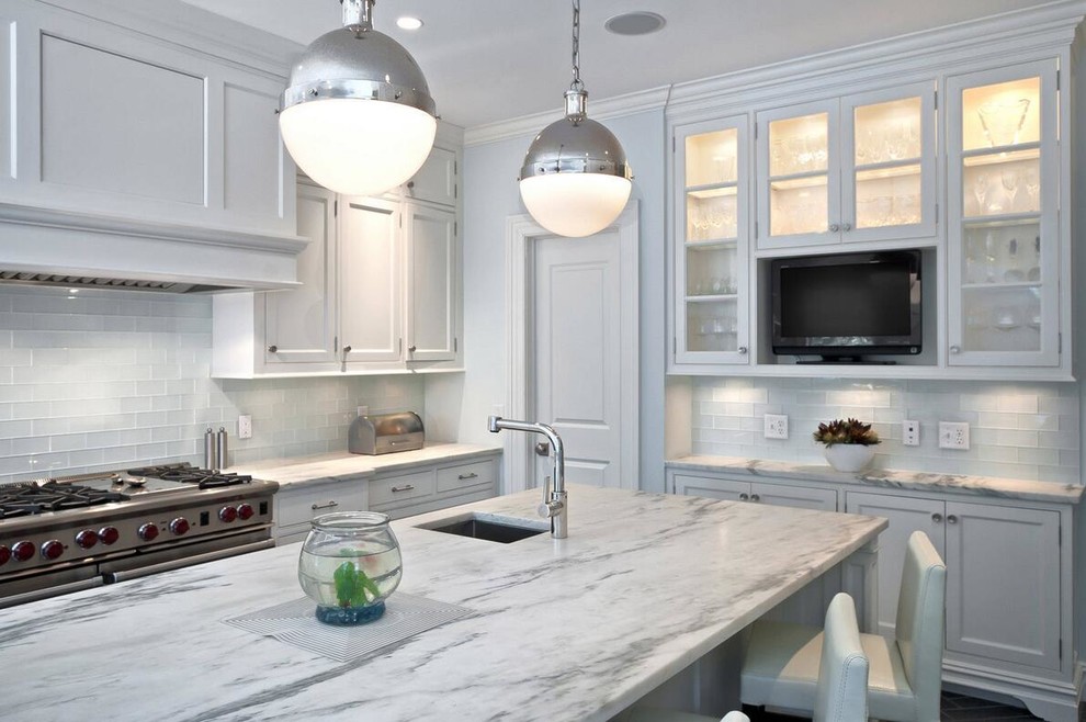 Kitchen - transitional dark wood floor kitchen idea with a single-bowl sink, shaker cabinets, white cabinets, marble countertops, white backsplash, glass tile backsplash, stainless steel appliances and an island