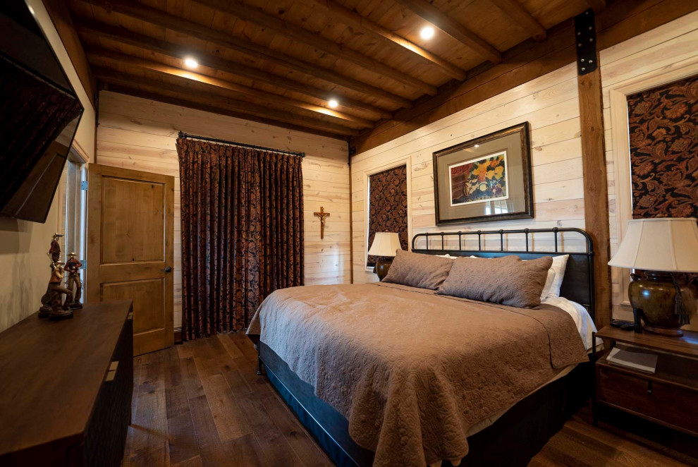 Imagen de dormitorio principal rústico de tamaño medio con paredes marrones, suelo de madera oscura, suelo marrón y vigas vistas