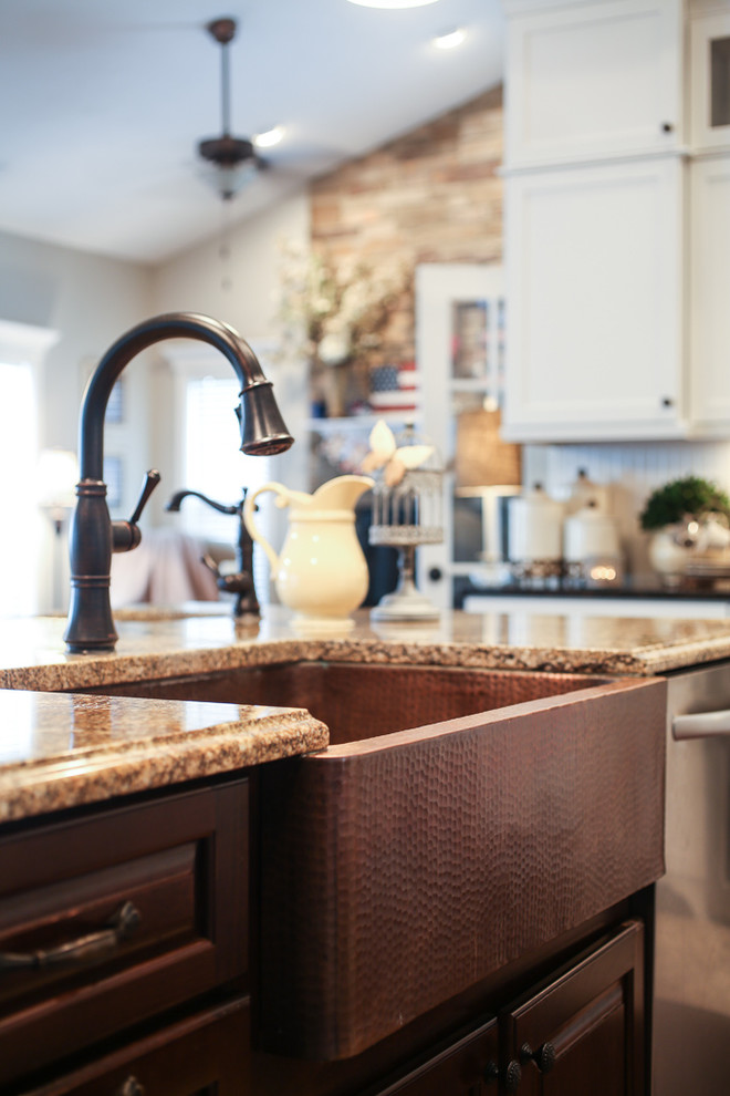 Open concept kitchen - transitional l-shaped dark wood floor open concept kitchen idea with a farmhouse sink, shaker cabinets, white cabinets, quartz countertops, white backsplash, stainless steel appliances and an island