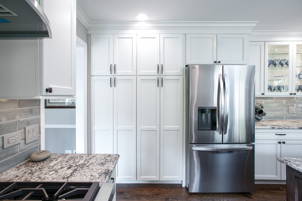 Inspiration for a mid-sized transitional u-shaped dark wood floor and brown floor open concept kitchen remodel in Chicago with a double-bowl sink, shaker cabinets, white cabinets, quartz countertops, blue backsplash, porcelain backsplash, stainless steel appliances, an island and gray countertops