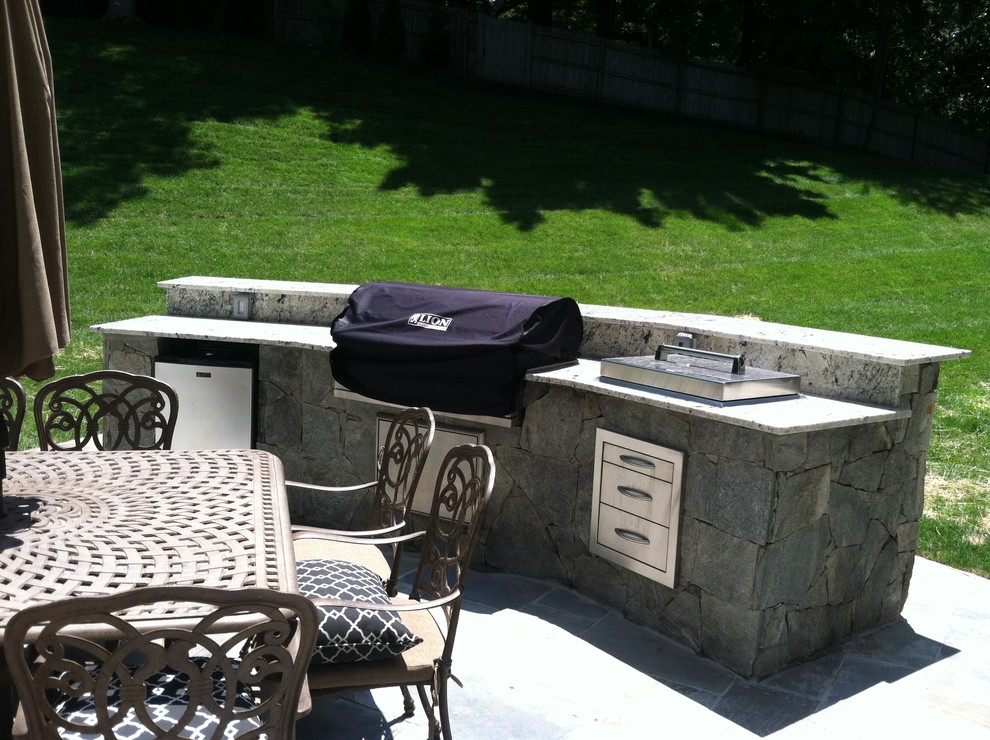 Photo of a large traditional backyard patio in DC Metro with an outdoor kitchen, natural stone pavers and no cover.