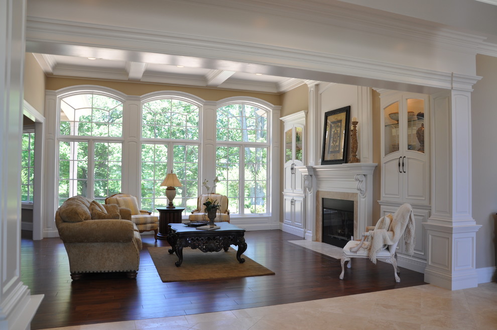 This is an example of a traditional living room in Cincinnati with dark hardwood floors and a standard fireplace.