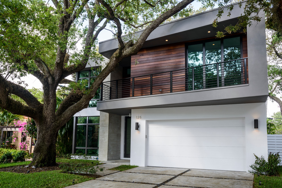 Photo of a large modern two-storey multi-coloured exterior in Miami with mixed siding and a flat roof.