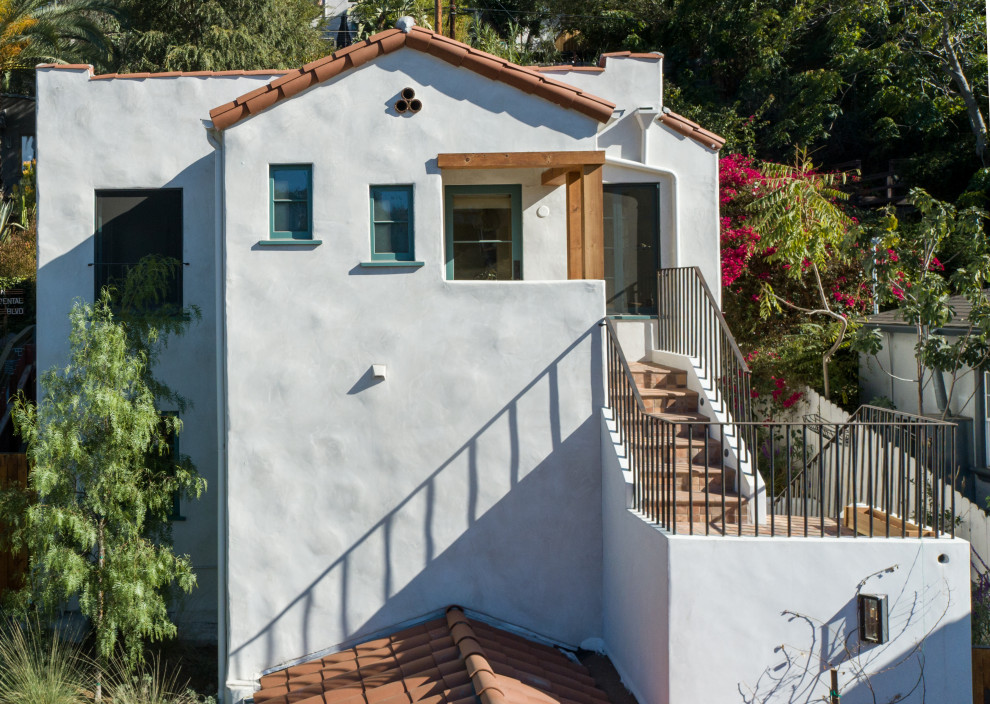 Mittelgroßes, Zweistöckiges Mediterranes Haus mit Putzfassade, weißer Fassadenfarbe und Ziegeldach in Los Angeles