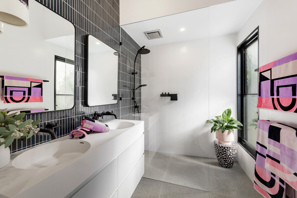 Inspiration for a contemporary 3/4 bathroom in Melbourne with flat-panel cabinets, white cabinets, a curbless shower, black tile, an integrated sink, grey floor, an open shower, white benchtops, a double vanity and a floating vanity.