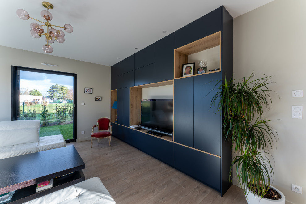 Modelo de salón abierto ecléctico grande sin chimenea con paredes azules, suelo laminado y televisor independiente