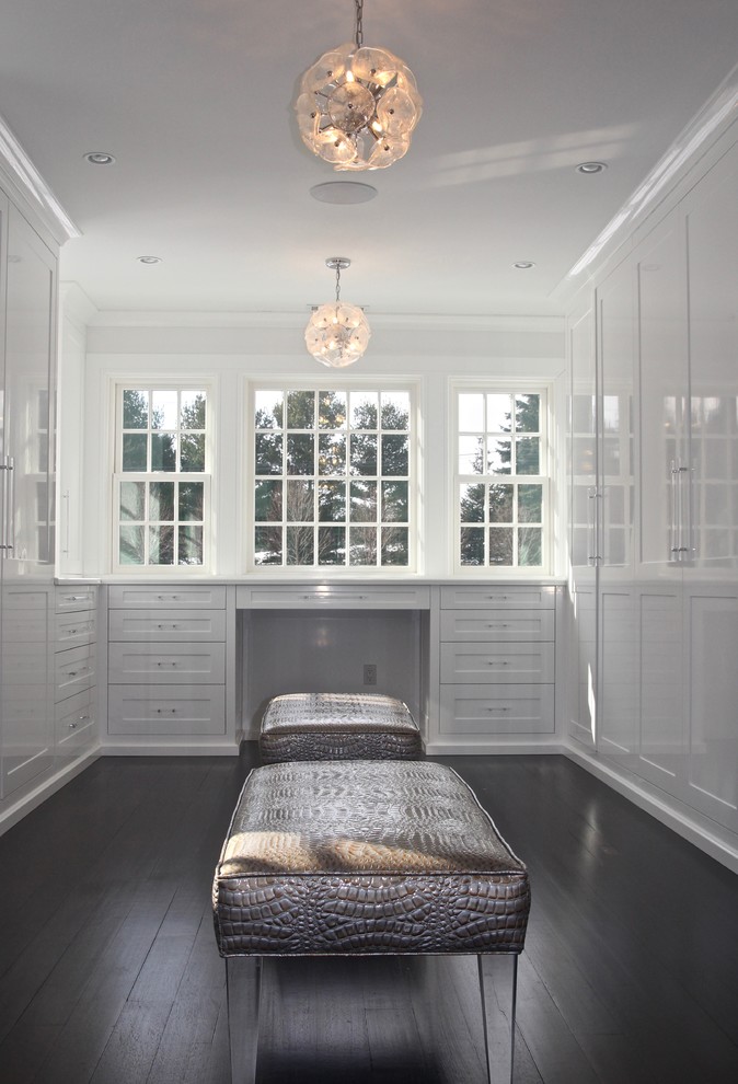Inspiration for a large transitional women's walk-in wardrobe in New York with white cabinets, dark hardwood floors and shaker cabinets.