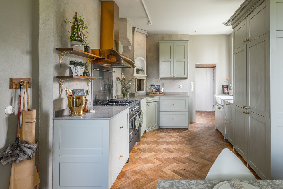 Design ideas for a mid-sized traditional galley eat-in kitchen in Stockholm with shaker cabinets, marble benchtops, no island, a farmhouse sink, grey cabinets, panelled appliances, medium hardwood floors and brown floor.