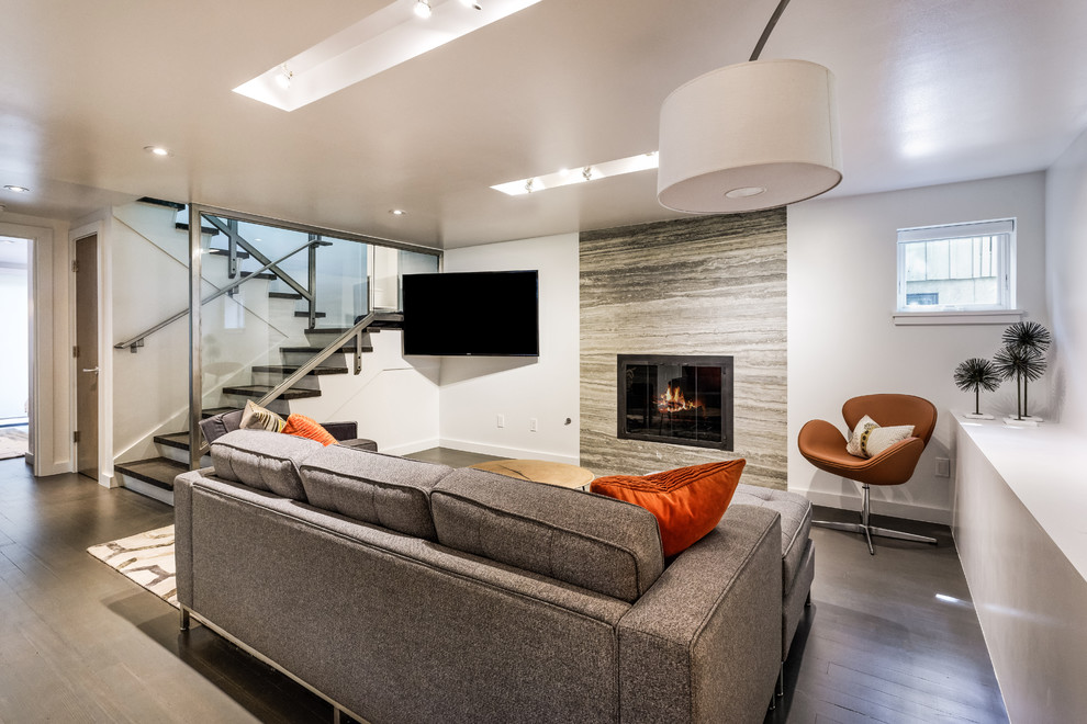 Photo of a large contemporary open concept family room in Denver with white walls, dark hardwood floors, a standard fireplace, a tile fireplace surround, a wall-mounted tv and brown floor.