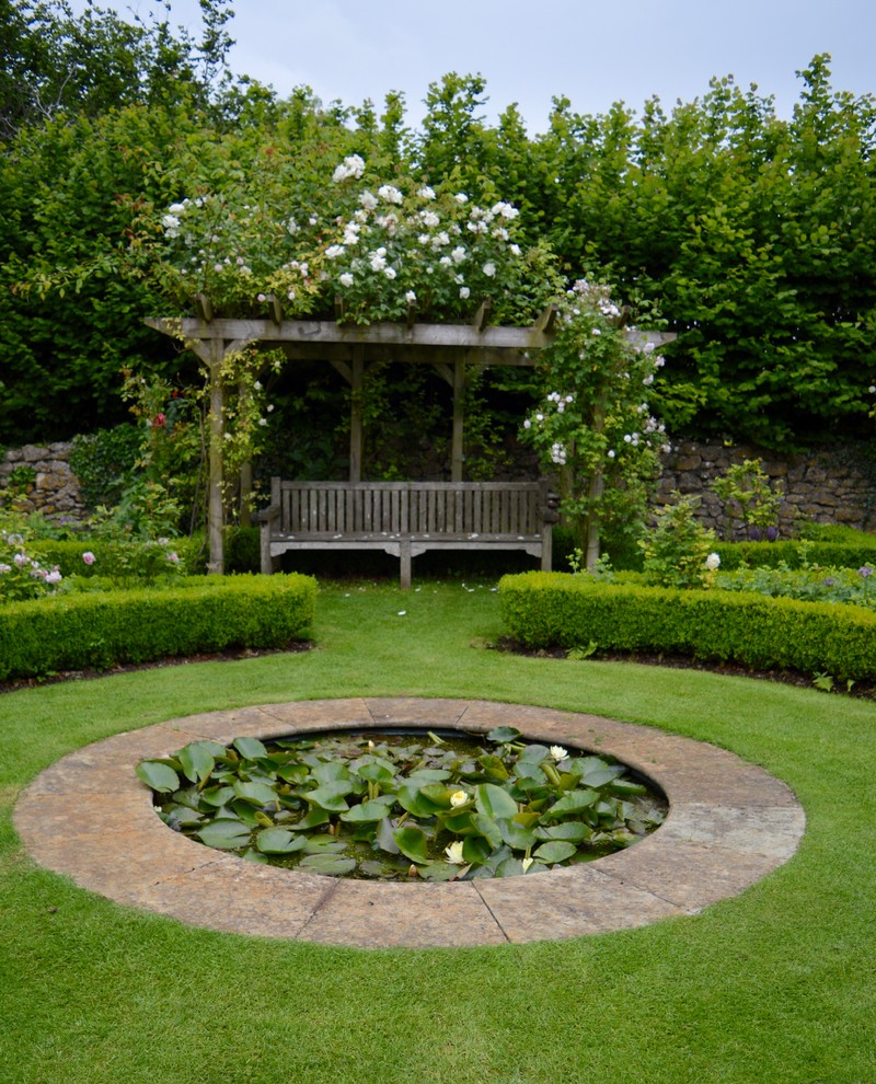 Imagen de jardín campestre grande en patio trasero con exposición parcial al sol y adoquines de piedra natural