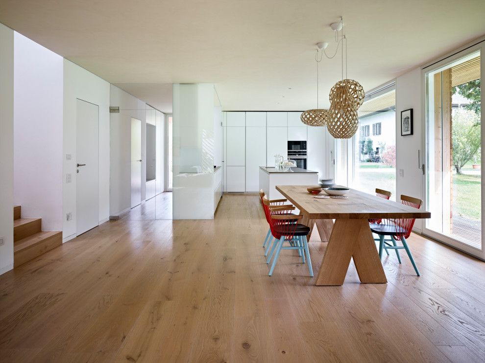 Стильный дизайн: кухня-гостиная в скандинавском стиле с паркетным полом среднего тона и бежевым полом - последний тренд