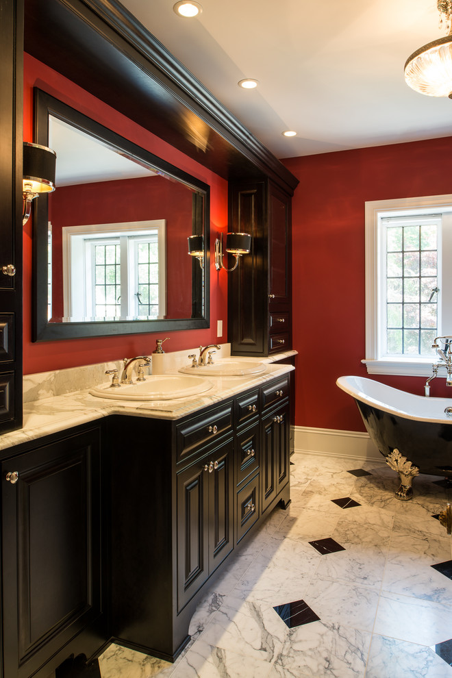 Traditional master bathroom in Philadelphia with raised-panel cabinets, a claw-foot tub, red walls, marble floors and marble benchtops.
