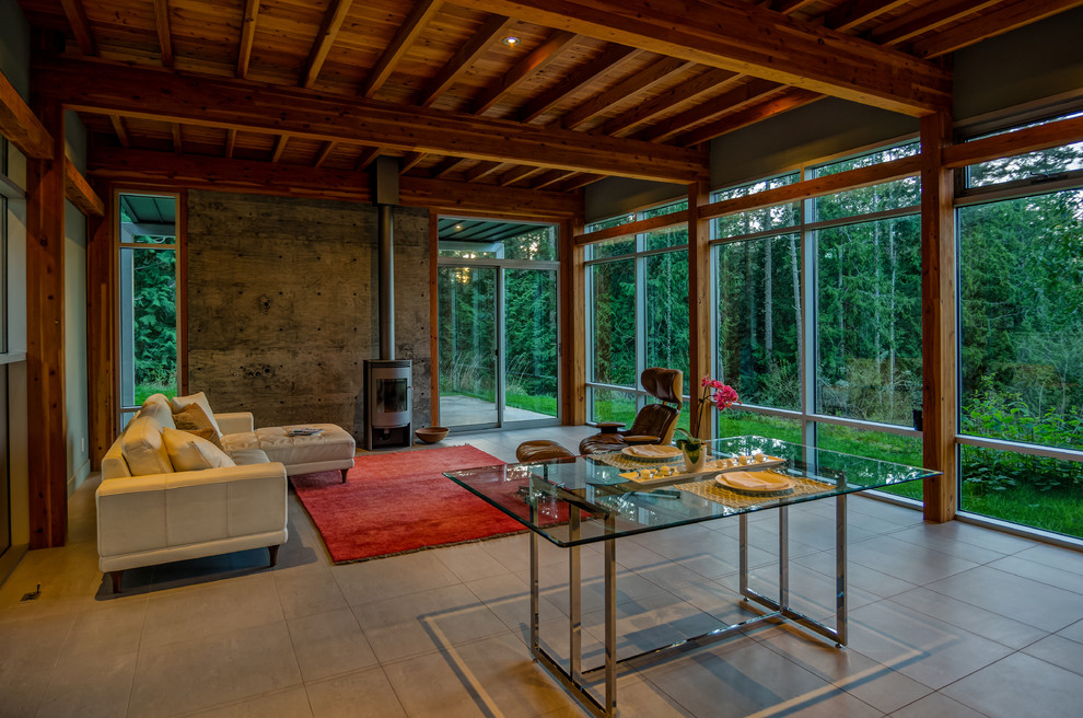 This is an example of a mid-sized modern formal open concept living room in Seattle with grey walls, a wood stove, porcelain floors, a metal fireplace surround, no tv and grey floor.