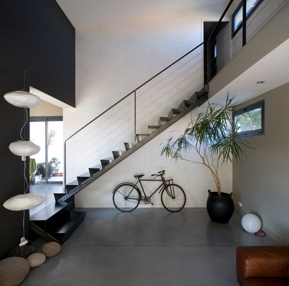 Photo of a contemporary metal straight staircase in Toulouse with metal risers and cable railing.