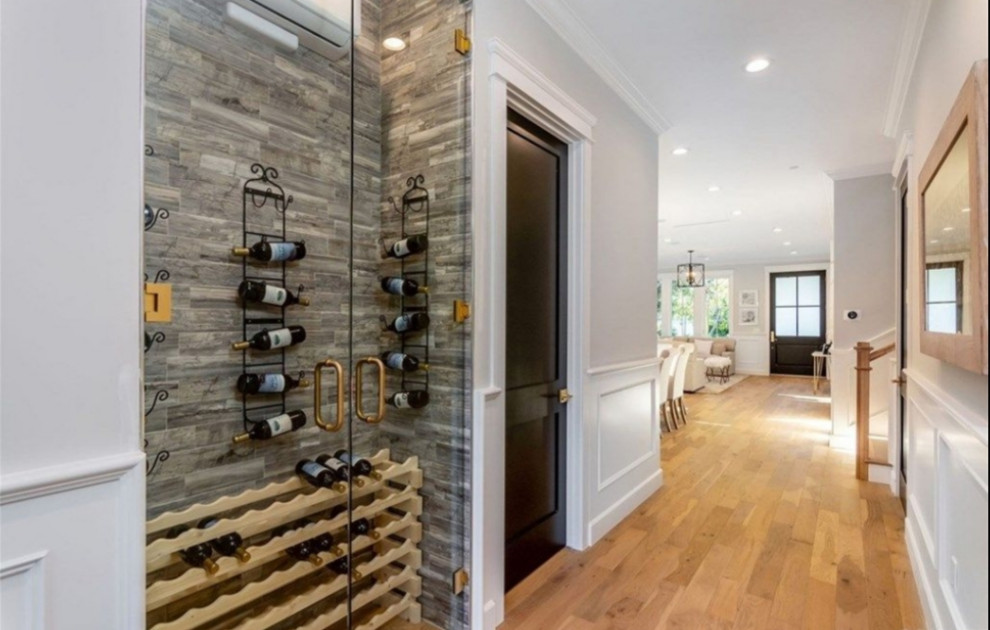 Design ideas for a mid-sized traditional wine cellar in Los Angeles with medium hardwood floors, display racks and brown floor.