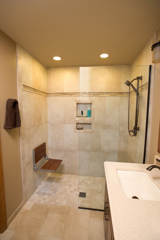 Photo of a mid-sized modern master bathroom in Denver with raised-panel cabinets, brown cabinets, a curbless shower, beige tile, stone tile, laminate benchtops, an open shower, beige walls, travertine floors, an undermount sink and beige floor.