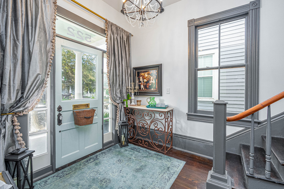Front door - transitional dark wood floor and black floor front door idea with white walls and a blue front door