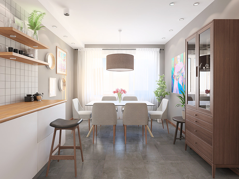 This is an example of a mid-sized scandinavian l-shaped eat-in kitchen in Other with a single-bowl sink, flat-panel cabinets, white cabinets, wood benchtops, grey splashback, stainless steel appliances, porcelain floors, no island, ceramic splashback, grey floor and brown benchtop.