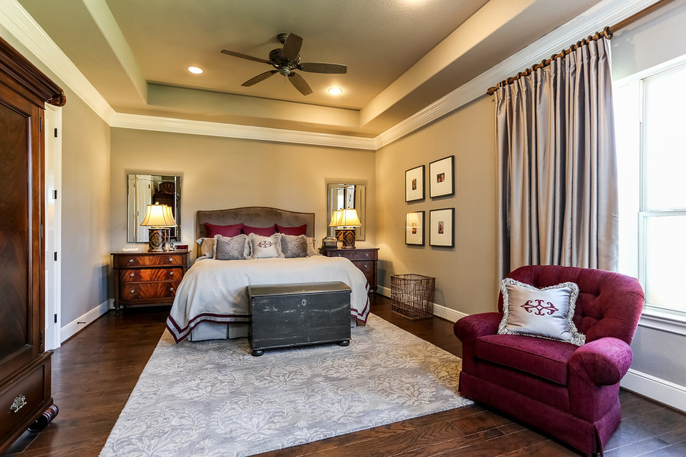 Large traditional master bedroom in Houston with grey walls and medium hardwood floors.