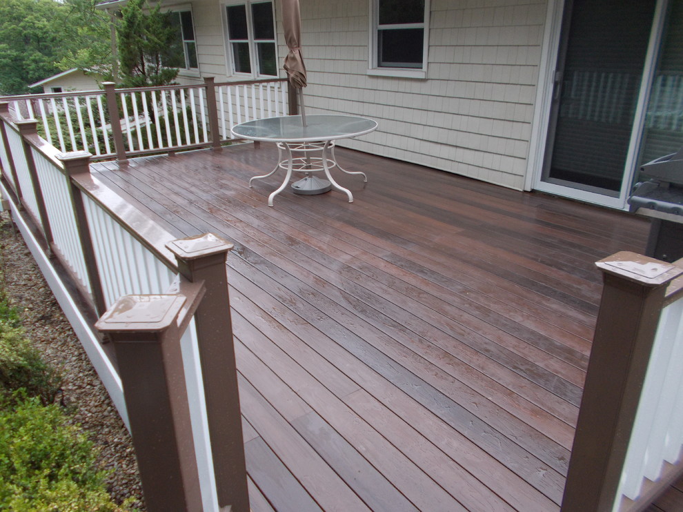This is an example of a mid-sized backyard deck in New York with a pergola.