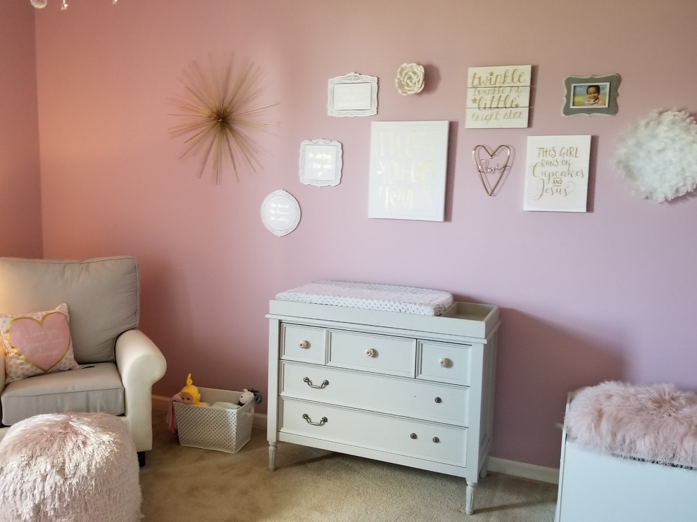 This is an example of a mid-sized traditional nursery for girls with pink walls, carpet and beige floor.