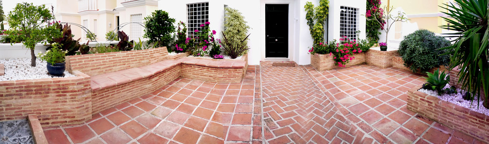 Inspiration for a small mediterranean front yard partial sun driveway in Other with brick pavers.