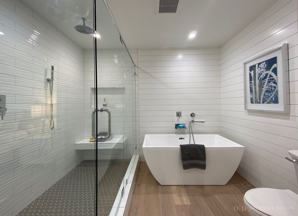 Exemple d'une grande salle de bain principale tendance avec une baignoire indépendante et parquet clair.