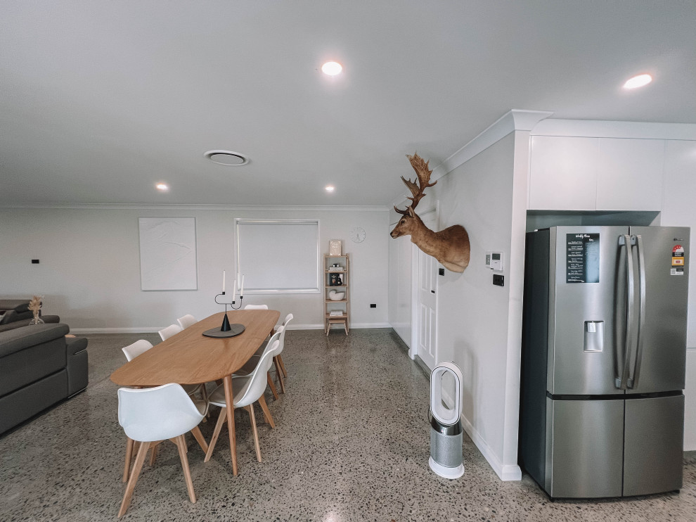 Design ideas for a mid-sized scandinavian open plan dining in Newcastle - Maitland with white walls, concrete floors, grey floor, timber and wood walls.