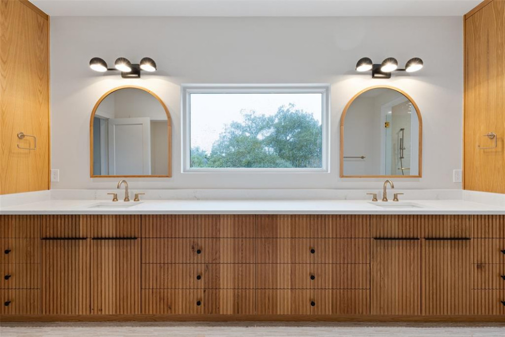 Exemple d'une grande salle de bain principale moderne en bois brun avec un placard à porte persienne, un carrelage blanc, un mur blanc, un lavabo encastré, un plan de toilette en marbre, un sol blanc, un plan de toilette blanc, une niche, meuble double vasque et meuble-lavabo encastré.