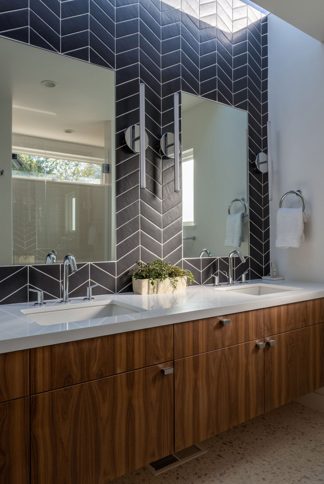 Inspiration for a mid-sized contemporary master bathroom in San Francisco with flat-panel cabinets, dark wood cabinets, a curbless shower, a two-piece toilet, black tile, porcelain tile, white walls, terrazzo floors, an undermount sink, engineered quartz benchtops, white floor, a hinged shower door and white benchtops.