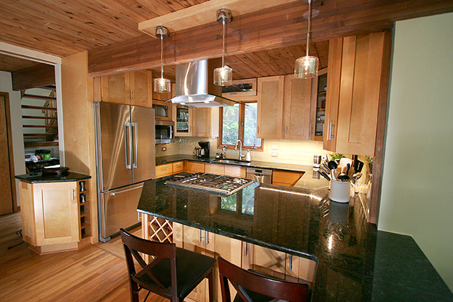 Inspiration for a small transitional l-shaped porcelain tile eat-in kitchen remodel with shaker cabinets, light wood cabinets, granite countertops, beige backsplash, glass tile backsplash, stainless steel appliances and a peninsula