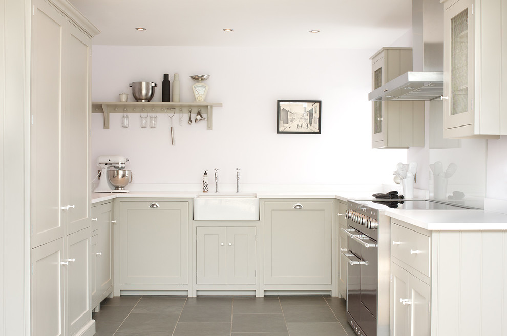This is an example of a mid-sized country u-shaped kitchen in Other with a farmhouse sink, shaker cabinets, grey cabinets, white splashback, glass sheet splashback, stainless steel appliances and slate floors.