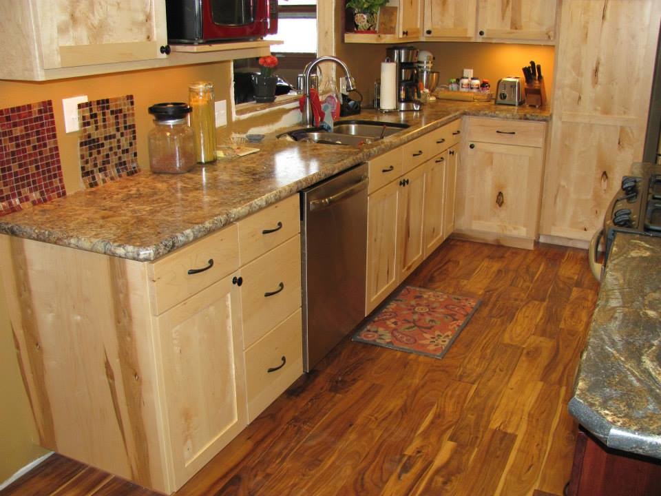 Inspiration for a mid-sized rustic l-shaped medium tone wood floor and brown floor eat-in kitchen remodel with a double-bowl sink, shaker cabinets, light wood cabinets, limestone countertops, stainless steel appliances and an island