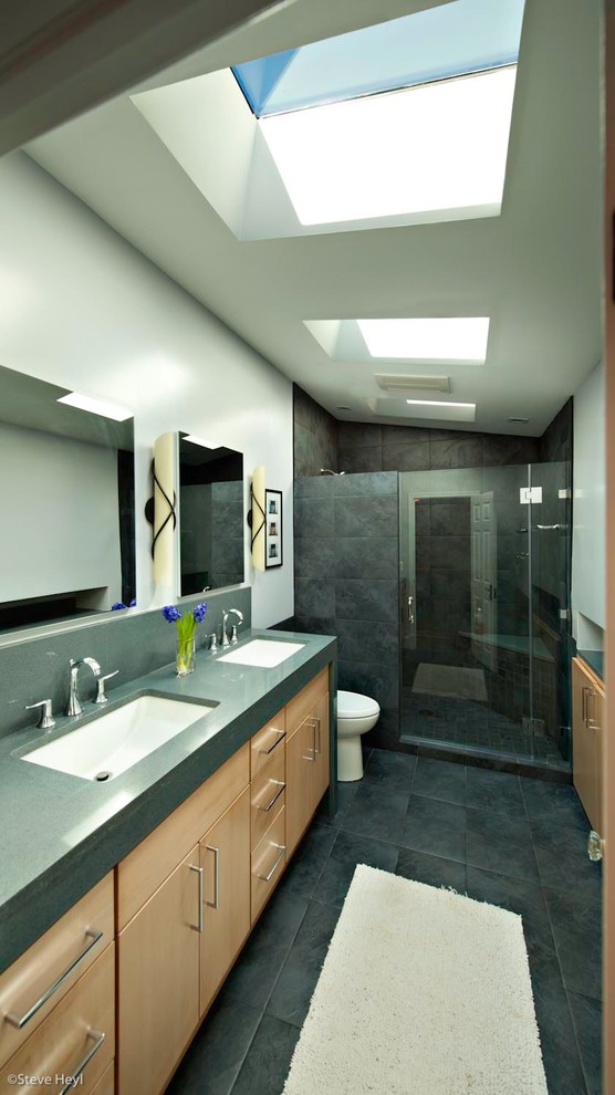 Mid-sized contemporary master bathroom in DC Metro with flat-panel cabinets, light wood cabinets, a one-piece toilet, grey walls, ceramic floors, an undermount sink and solid surface benchtops.