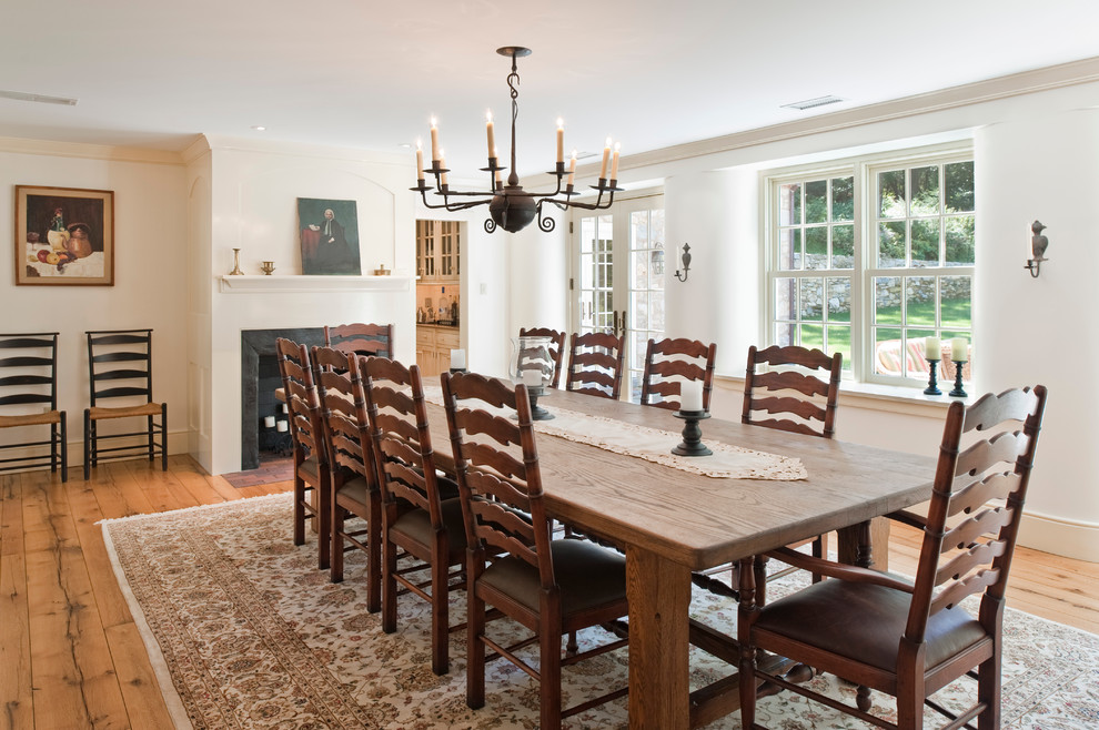 Inspiration for a mid-sized country separate dining room in Philadelphia with medium hardwood floors, a standard fireplace, white walls and brown floor.