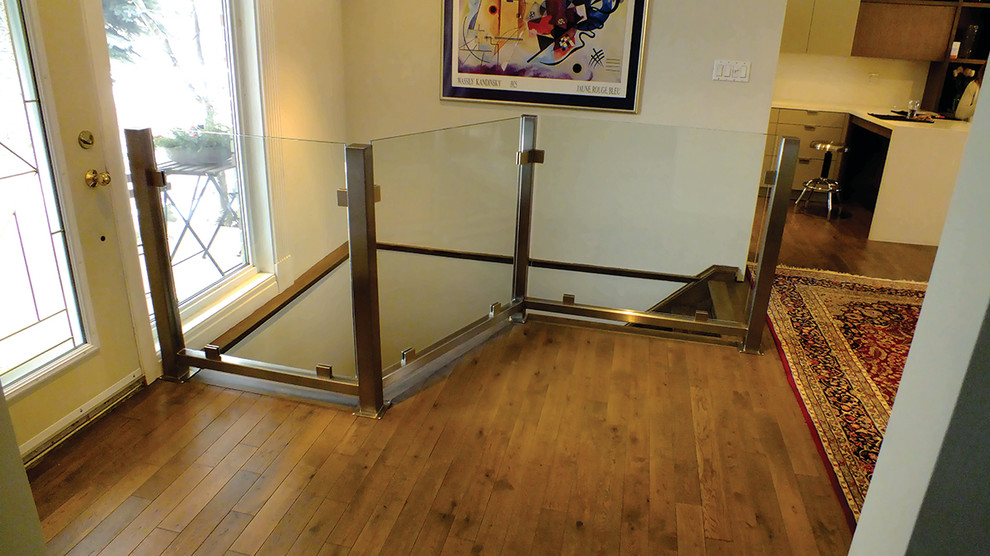 Photo of a mid-sized modern wood l-shaped staircase in Toronto with wood risers and glass railing.