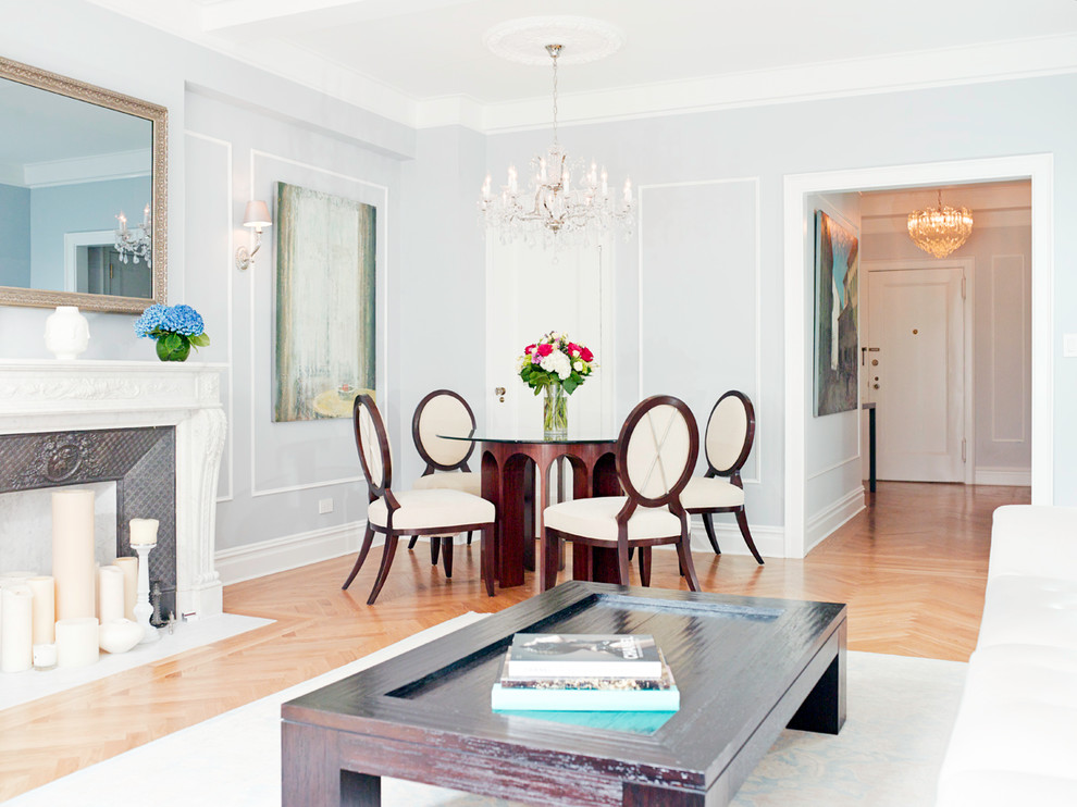 Mid-sized transitional separate dining room in New York with grey walls, light hardwood floors, a standard fireplace and a metal fireplace surround.