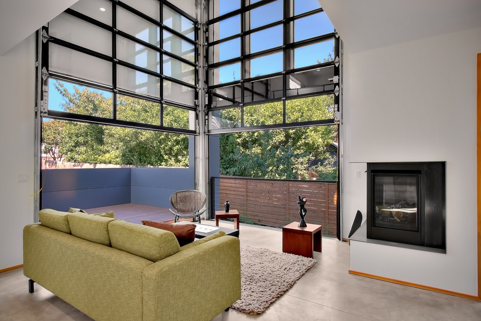 This is an example of a mid-sized contemporary open concept living room in Phoenix with white walls, concrete floors, a corner fireplace and a metal fireplace surround.