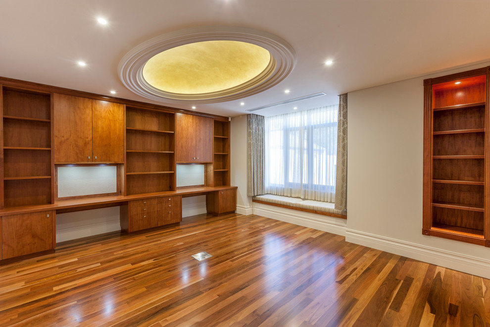 Design ideas for a large traditional study room in Perth with medium hardwood floors, a built-in desk and beige walls.