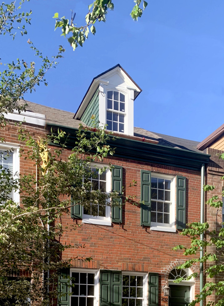 Пример оригинального дизайна: маленький, трехэтажный, кирпичный, разноцветный таунхаус в стиле кантри с вальмовой крышей, крышей из гибкой черепицы и коричневой крышей для на участке и в саду