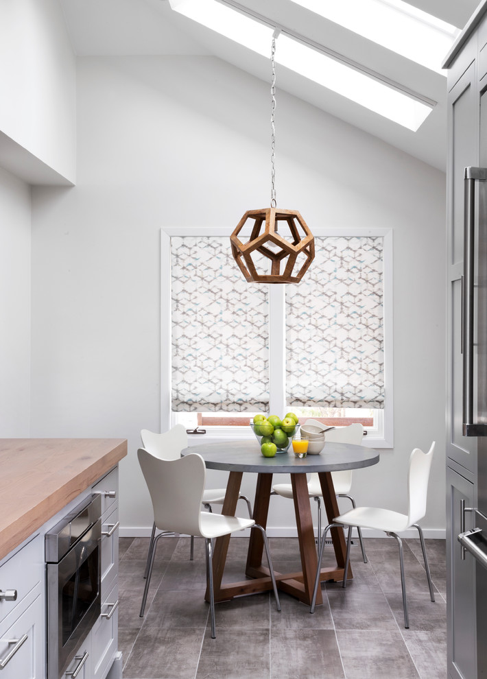 Inspiration for a contemporary kitchen/dining combo in New York with white walls and grey floor.