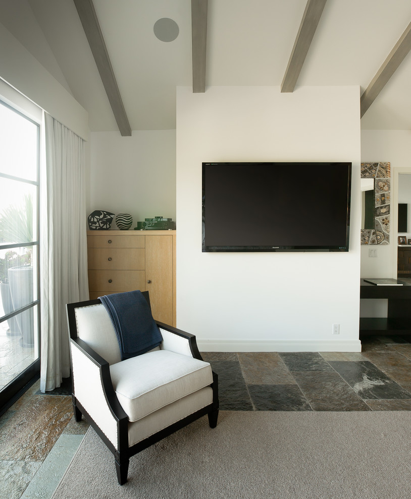 This is an example of a large contemporary guest bedroom in Los Angeles with white walls and slate floors.