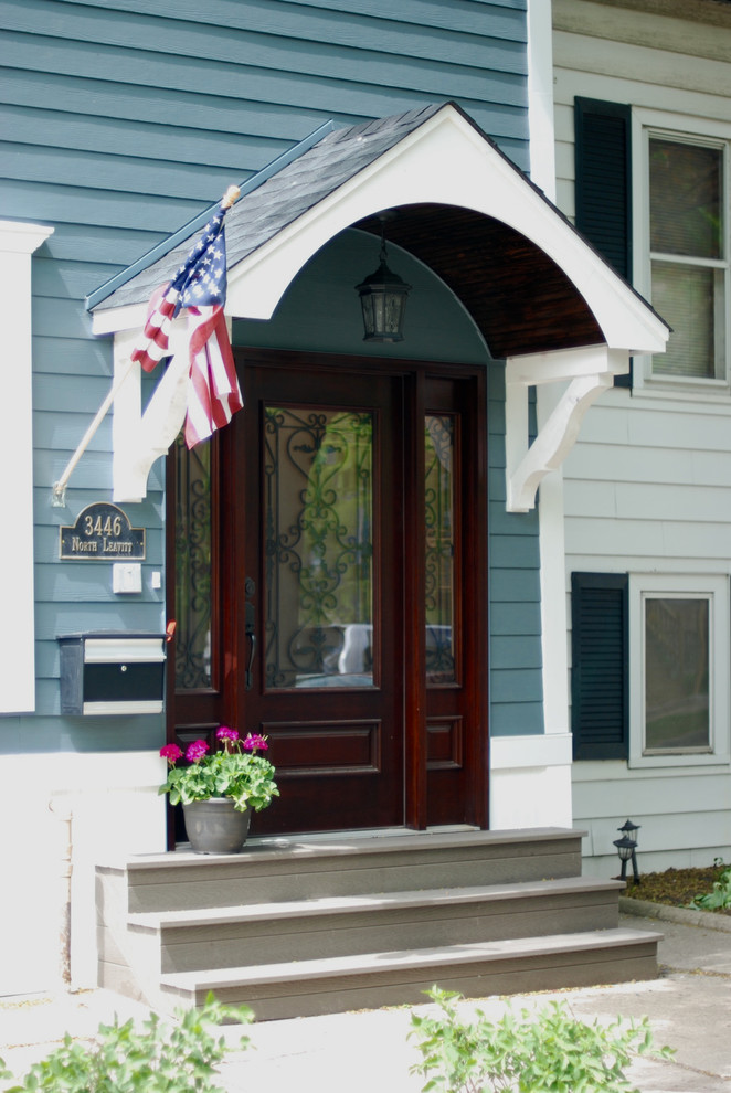 This is an example of a mid-sized traditional front door in Chicago with blue walls, a single front door, a dark wood front door, concrete floors and beige floor.