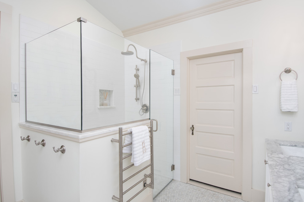 ニューオリンズにある中くらいなコンテンポラリースタイルのおしゃれなマスターバスルーム (インセット扉のキャビネット、白いキャビネット、置き型浴槽、オープン型シャワー、分離型トイレ、白いタイル、サブウェイタイル、白い壁、モザイクタイル、アンダーカウンター洗面器、珪岩の洗面台、白い床、開き戸のシャワー、マルチカラーの洗面カウンター、ニッチ、洗面台2つ、造り付け洗面台、三角天井) の写真