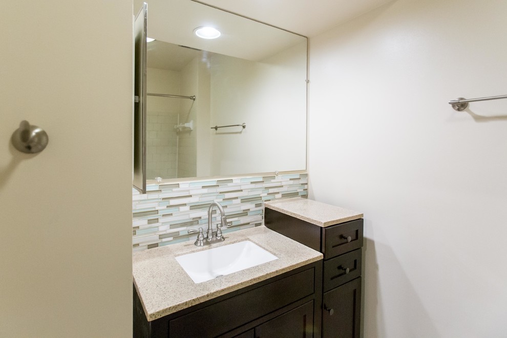 Small transitional 3/4 blue tile, gray tile, white tile and matchstick tile bathroom photo in DC Metro with recessed-panel cabinets, dark wood cabinets, gray walls, an undermount sink, granite countertops and gray countertops