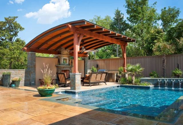 Inspiration for a large traditional backyard pool in Dallas with a water feature and tile.