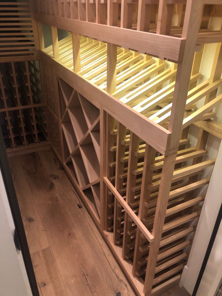 Kleiner Moderner Weinkeller mit hellem Holzboden, diagonaler Lagerung und beigem Boden in Orange County
