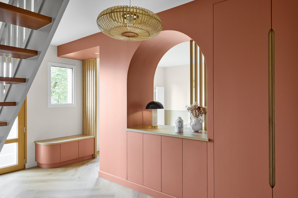 Inspiration pour un hall d'entrée minimaliste de taille moyenne avec un mur beige, parquet clair, une porte simple et une porte en bois clair.