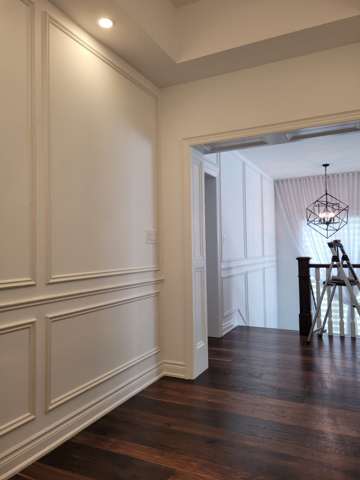 Trendy medium tone wood floor, brown floor, coffered ceiling and wainscoting hallway photo in Toronto with white walls